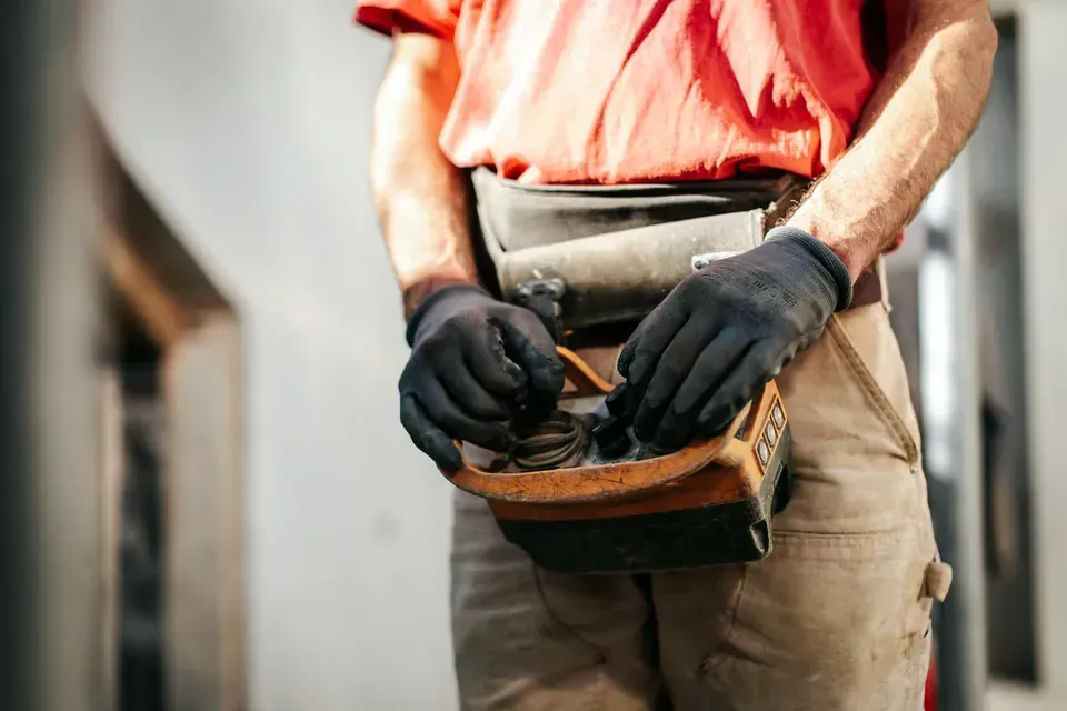 Gros plan sur la ceinture porte-outils d'un maçon