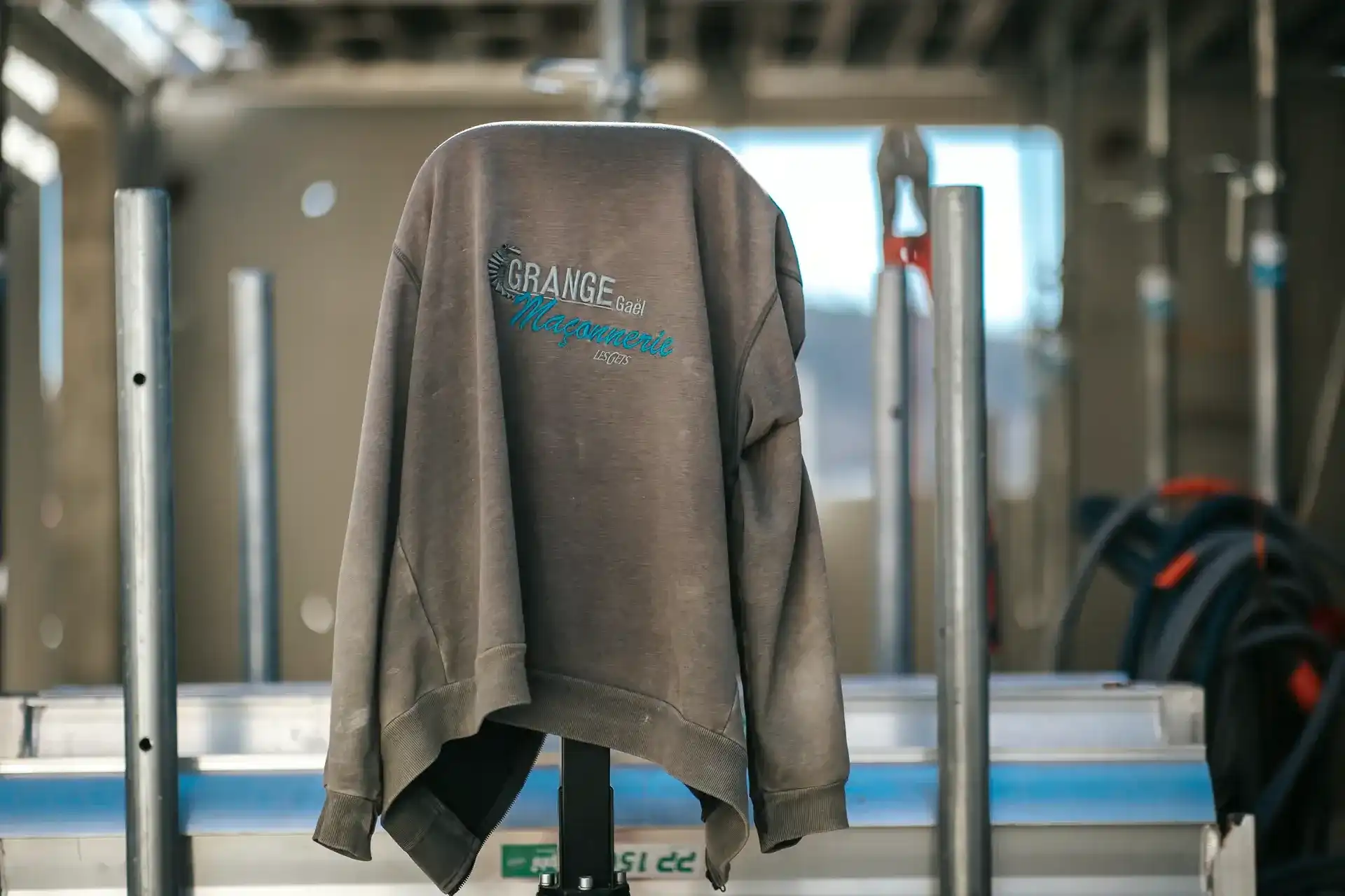 Sweat brodé Grange Gaël Maçonnerie posé sur un chantier