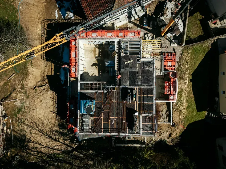 Vue aérienne d'un chantier d'envergure avec coffrages et grue