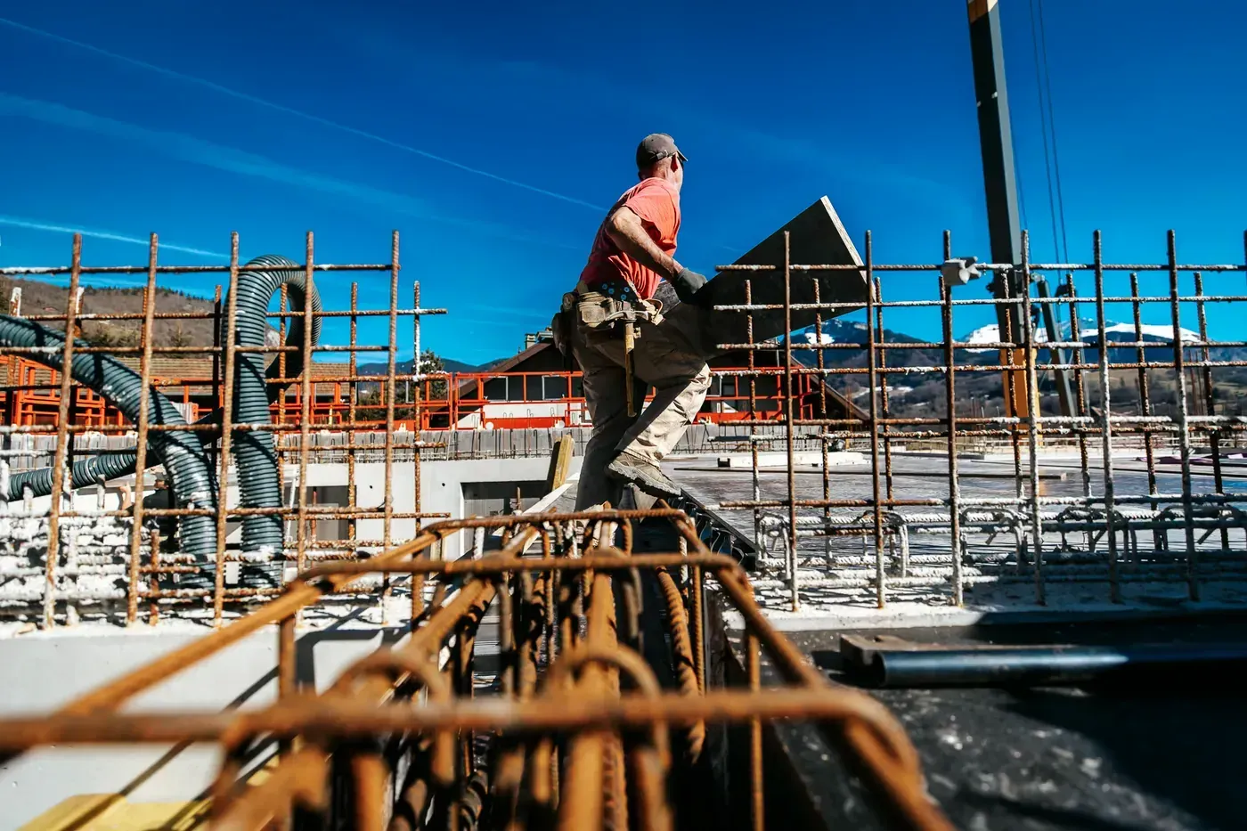Maçon travaillant sur le ferraillage d'une construction neuve, ciel bleu