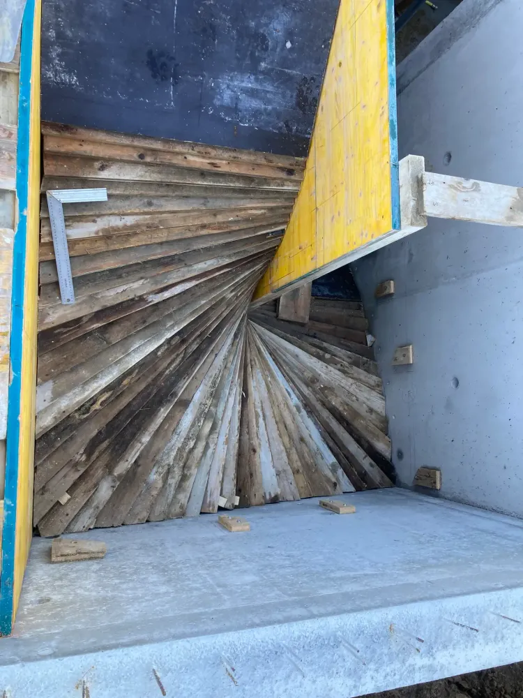 Coffrage bois en éventail formant la sous-face d'un escalier béton balancé