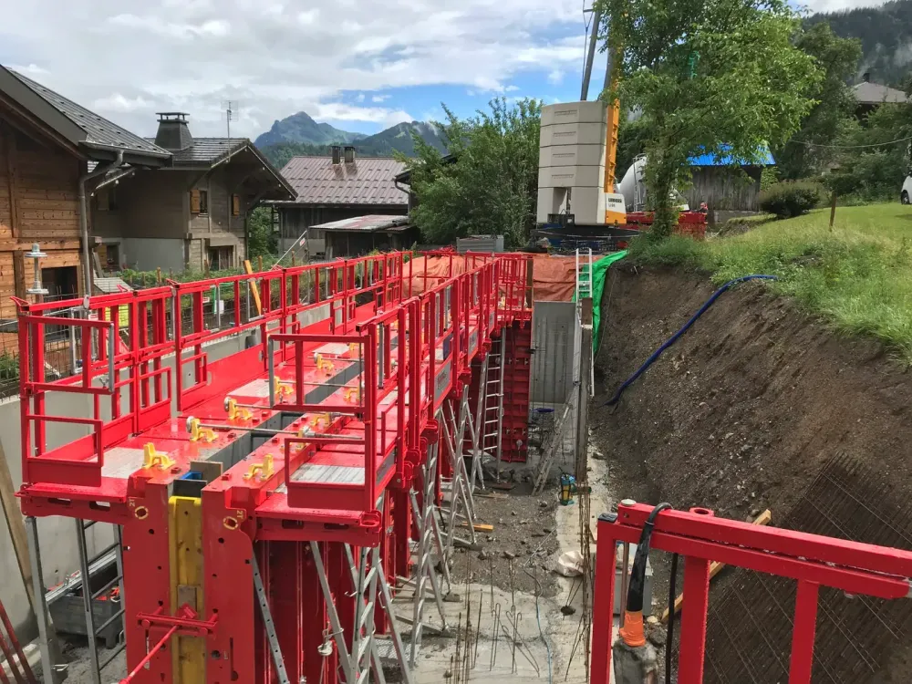 Banches rouges alignées pour le coulage d'un long mur de soutènement